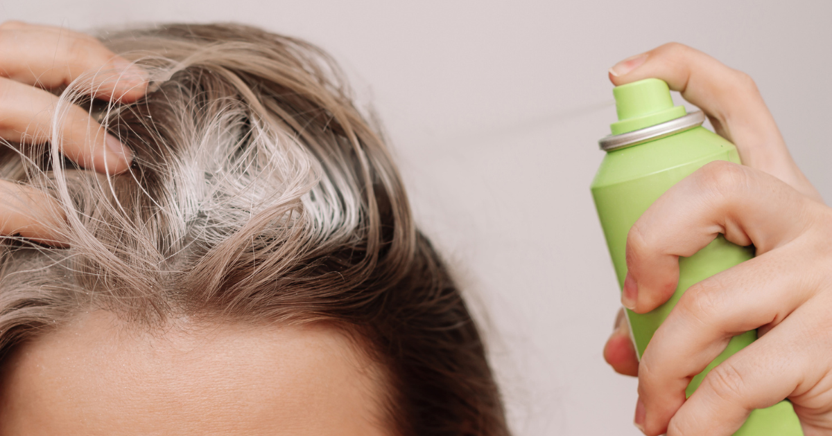 Close up of woman spraying dry shampoo in hair