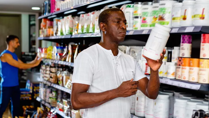 Man reading a supplement bottle