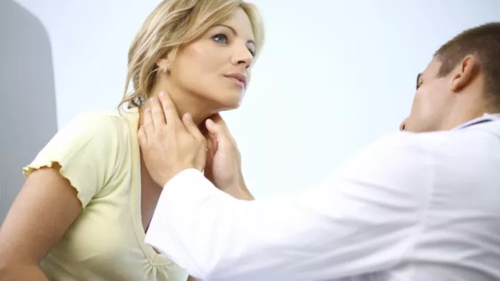 Doctor examining woman's neck