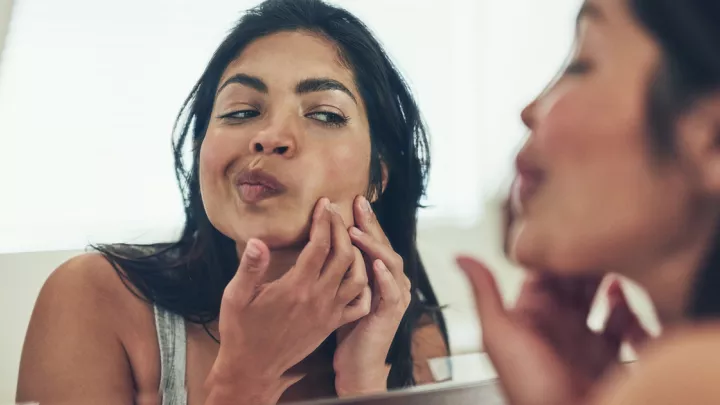 Woman squeezing pimple